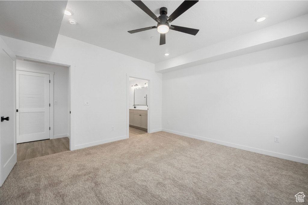 Unfurnished bedroom with recessed lighting, baseboards, light colored carpet, and ensuite bathroom