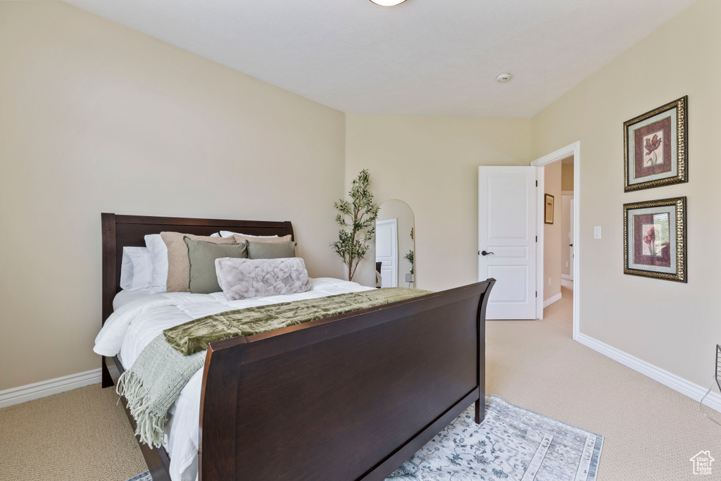 Bedroom featuring baseboards and light carpet