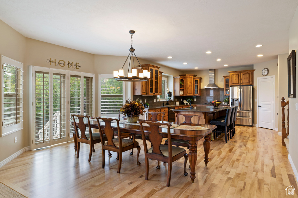 Dining room with baseboards, light wood-style floors, a chandelier, and recessed lighting