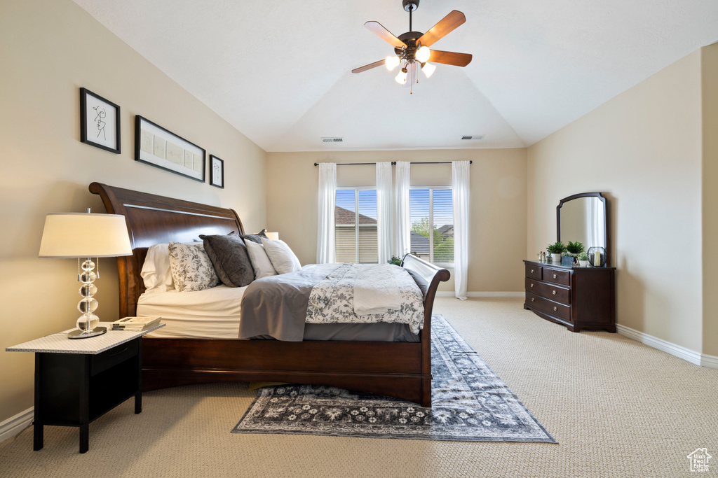 Bedroom with baseboards, light carpet, a ceiling fan, and vaulted ceiling