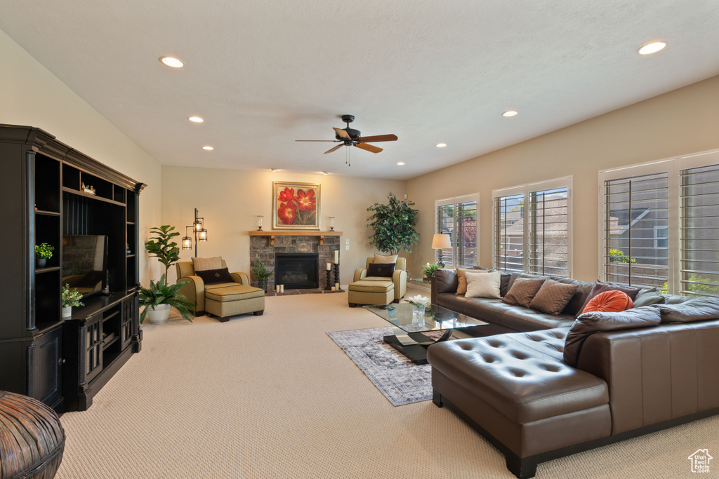 Living area featuring light colored carpet, recessed lighting, a ceiling fan, and a fireplace