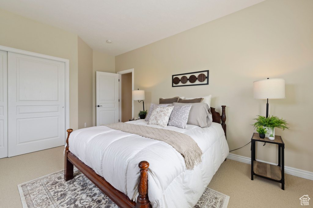 Bedroom featuring baseboards and light carpet