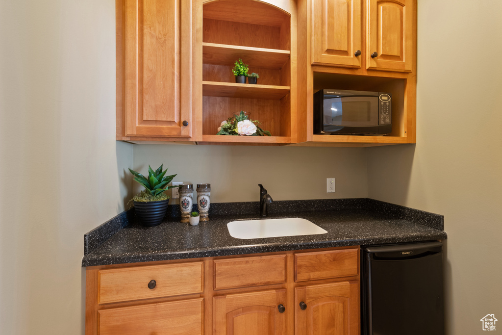 Bar featuring a sink and black appliances
