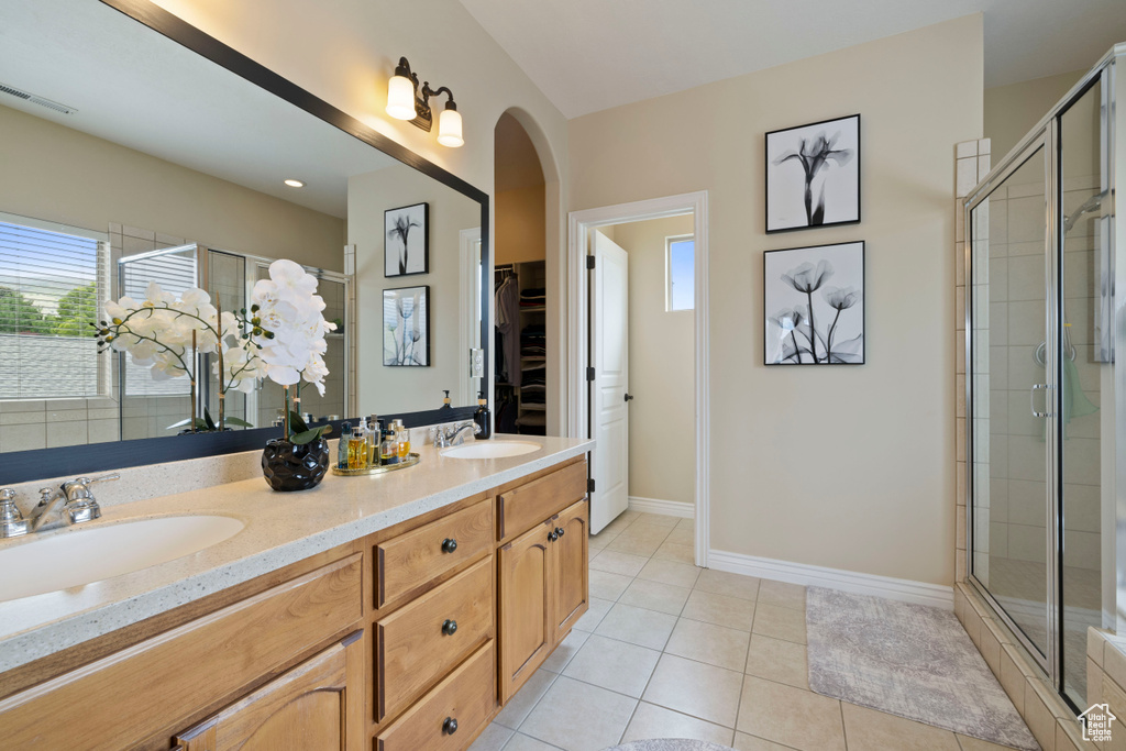 Full bath featuring a sink, a walk in closet, and a shower stall