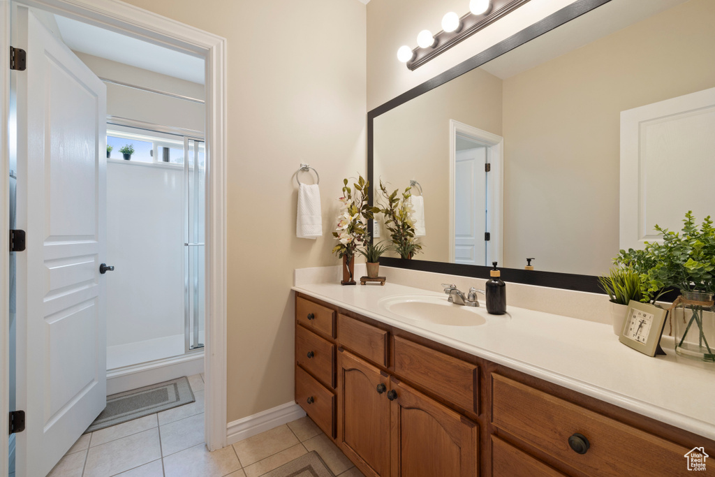 Bathroom with a shower stall, baseboards, tile patterned floors, and vanity