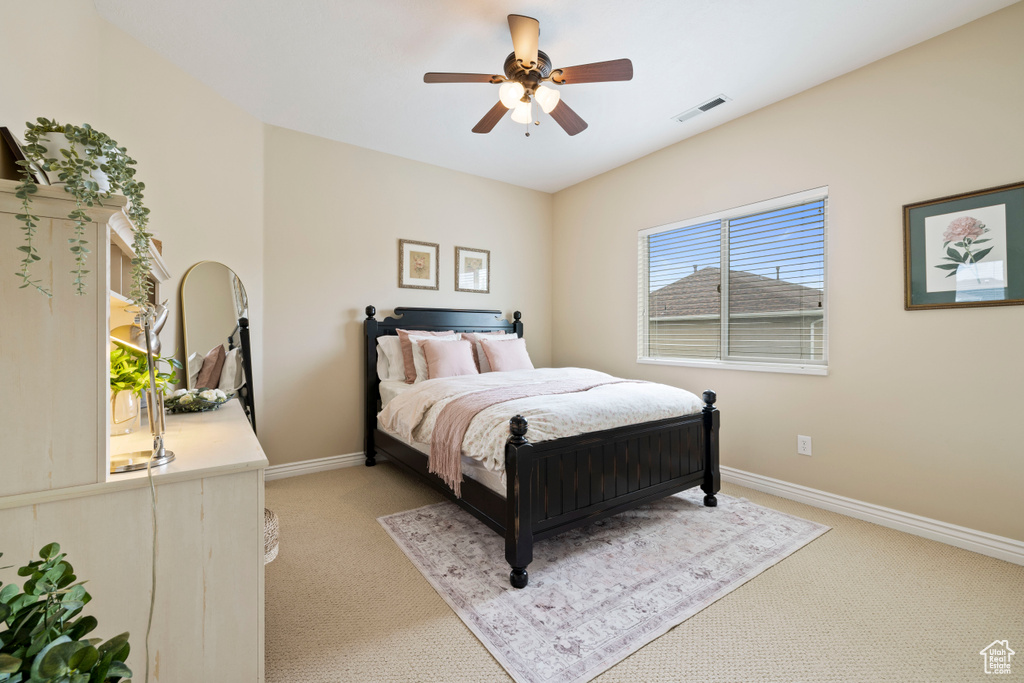 Bedroom with ceiling fan, light carpet, and baseboards