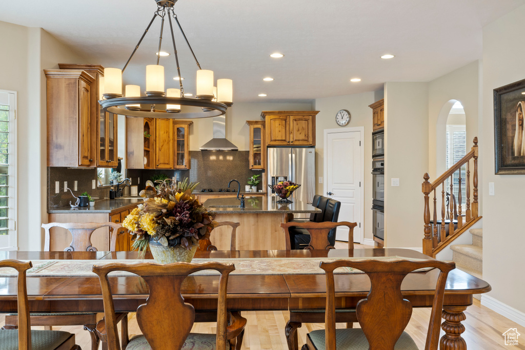 Dining area featuring recessed lighting, stairway, an inviting chandelier, baseboards, and light wood-style floors