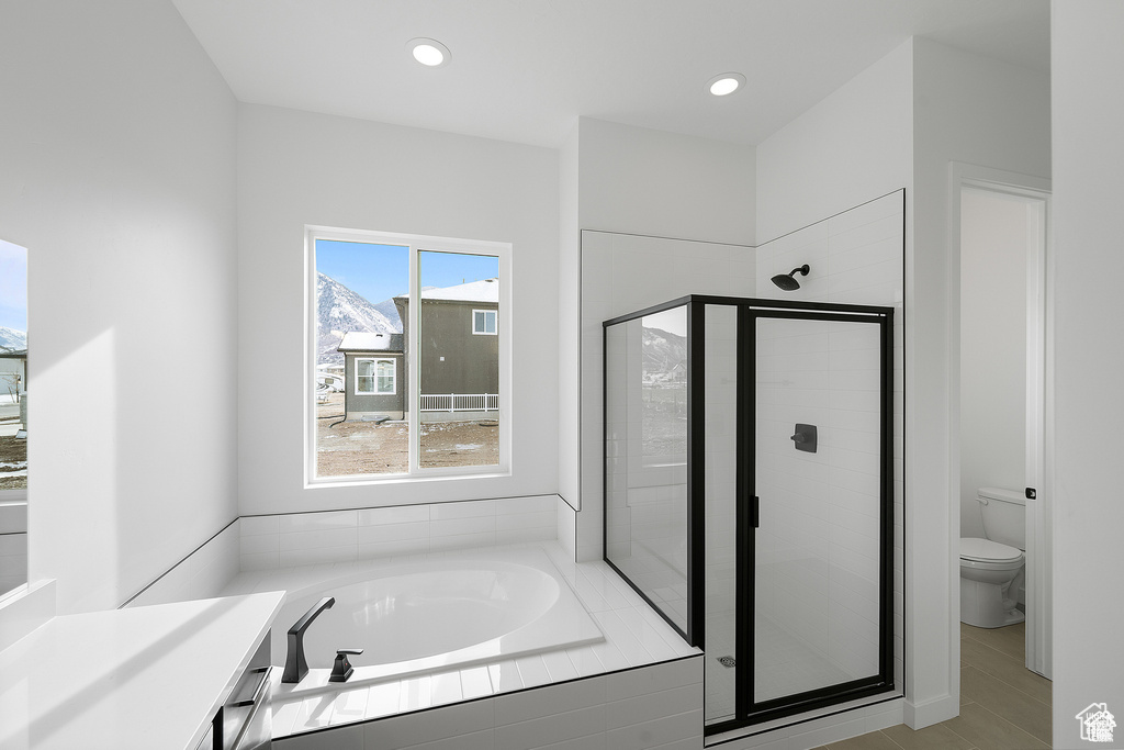 Full bath with toilet, recessed lighting, a garden tub, and a stall shower