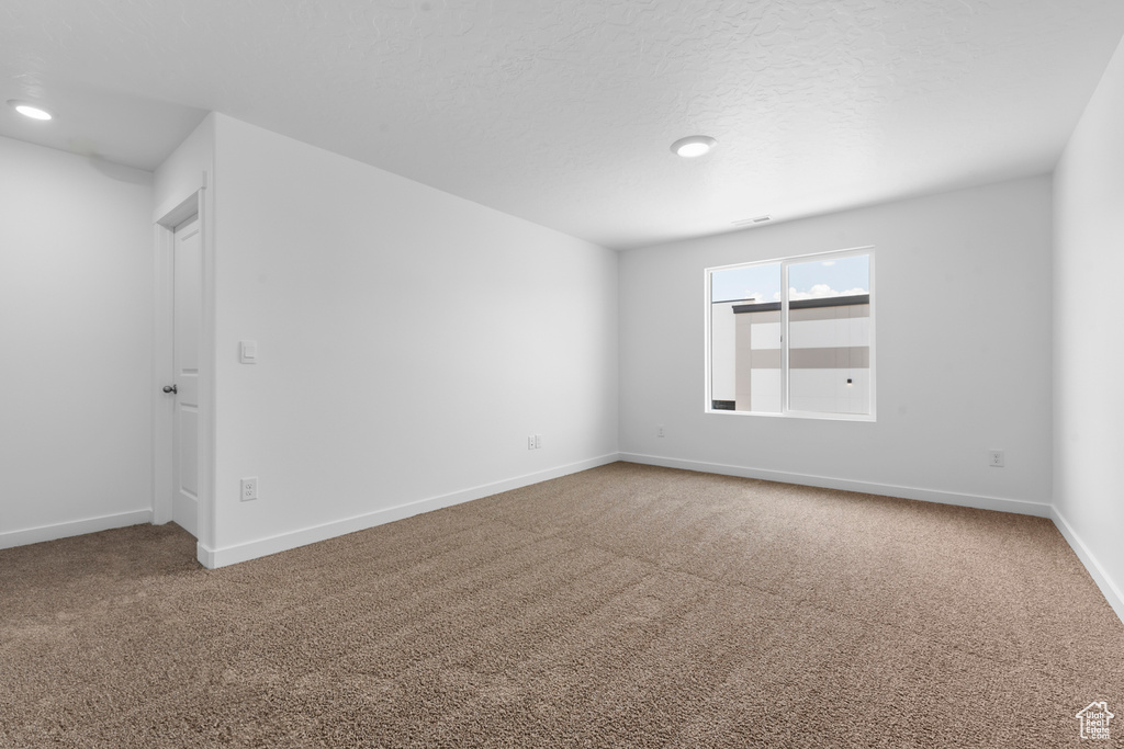Carpeted empty room featuring baseboards and recessed lighting