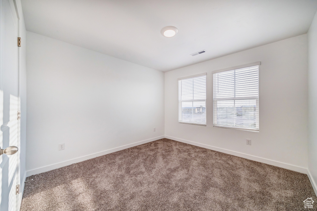 Unfurnished room featuring baseboards, carpet, and visible vents