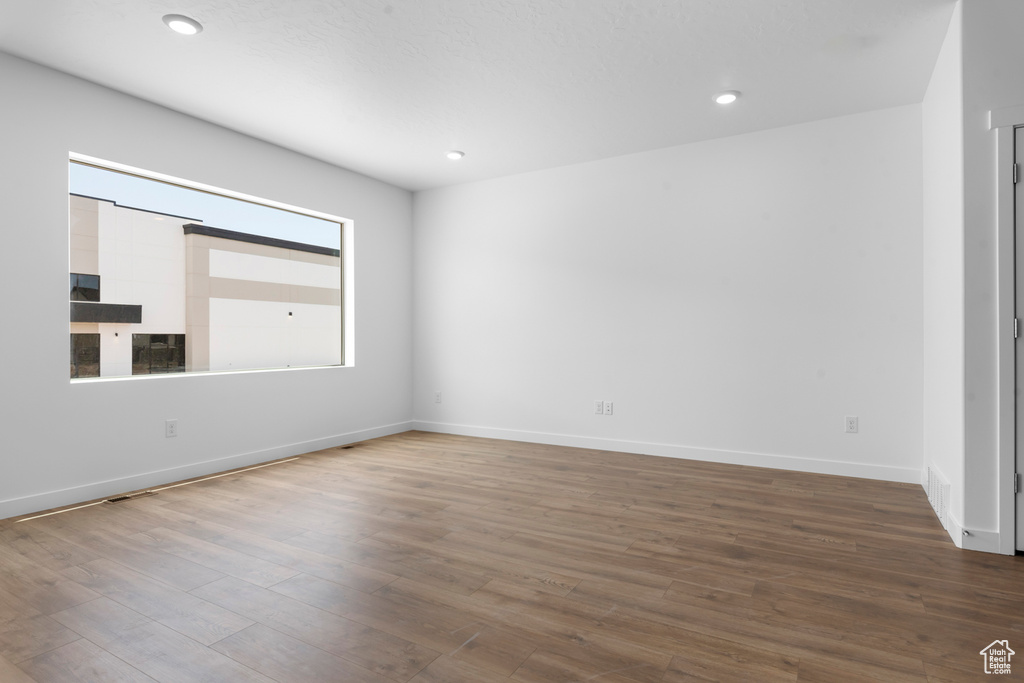 Unfurnished room featuring baseboards, recessed lighting, and wood finished floors