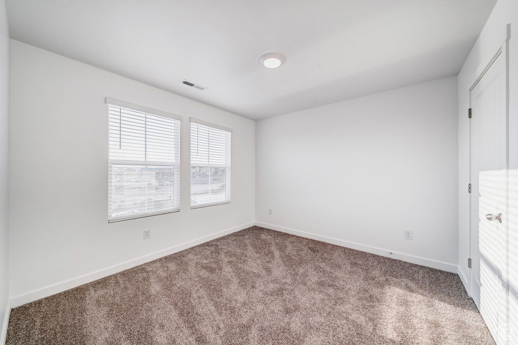 Unfurnished bedroom featuring baseboards, visible vents, and carpet
