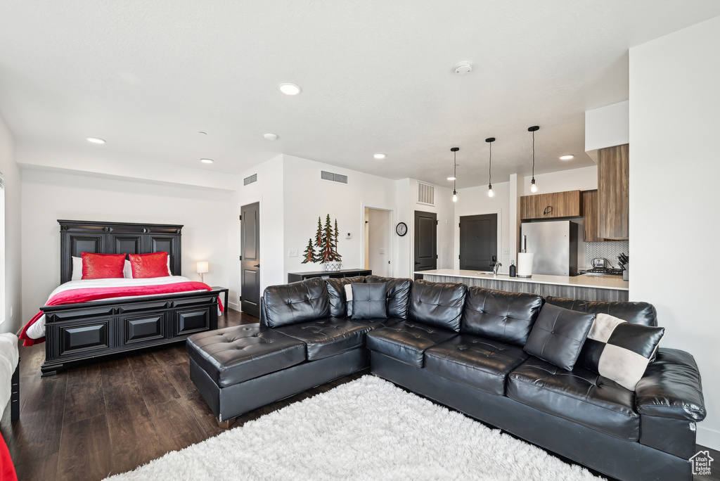 Living room with recessed lighting, visible vents, and dark wood-style floors