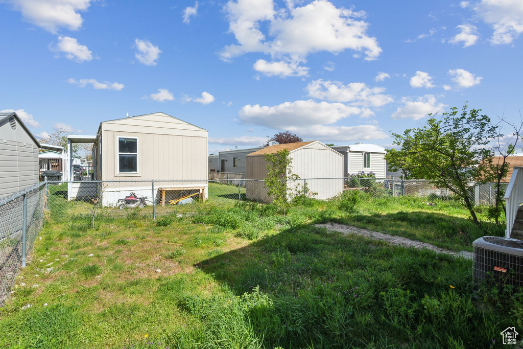 View of yard with a fenced backyard and cooling unit