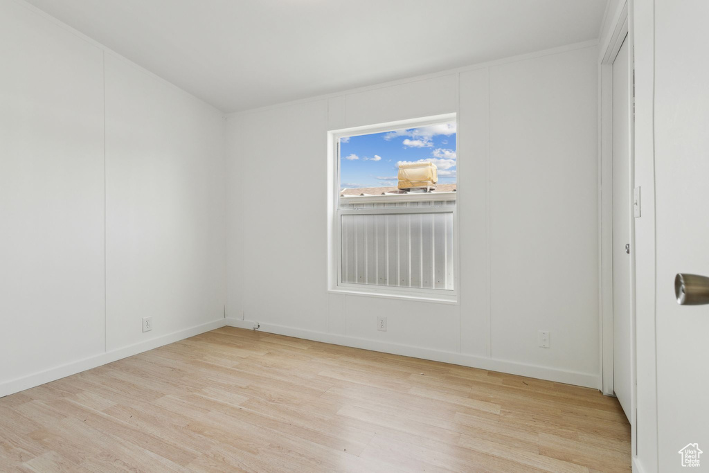 Spare room with baseboards and wood finished floors