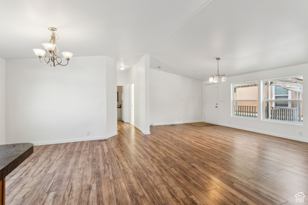 Unfurnished dining area with baseboards, an inviting chandelier, and wood finished floors