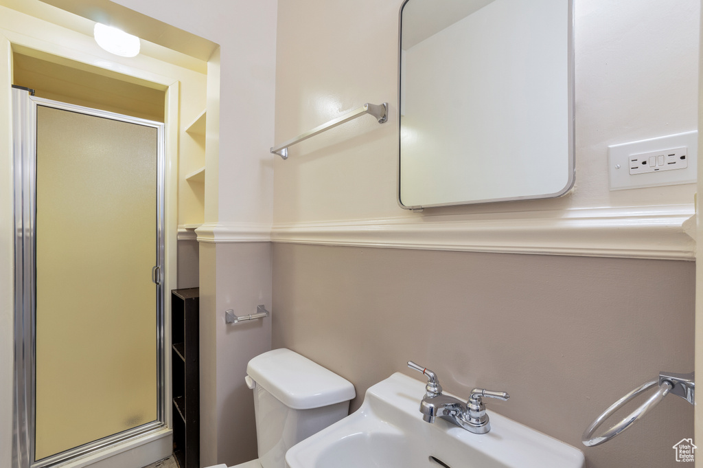 Full bathroom featuring a sink, a stall shower, and toilet