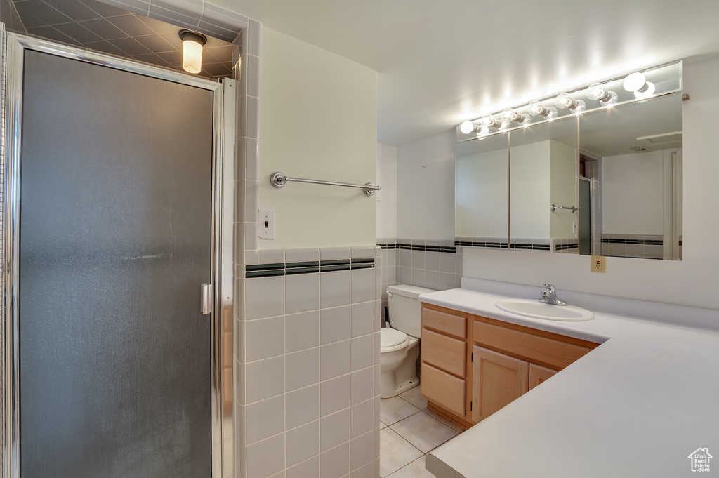 Full bathroom with toilet, a shower stall, tile patterned flooring, and vanity