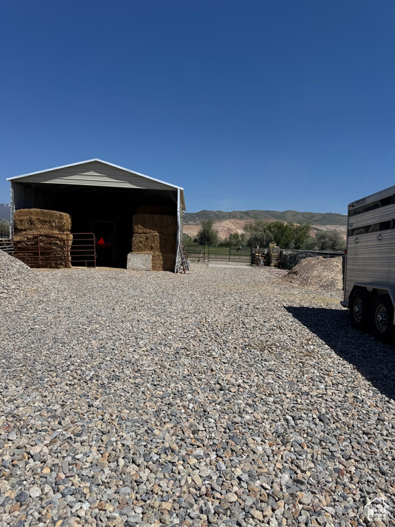View of property exterior featuring fence and a mountain view