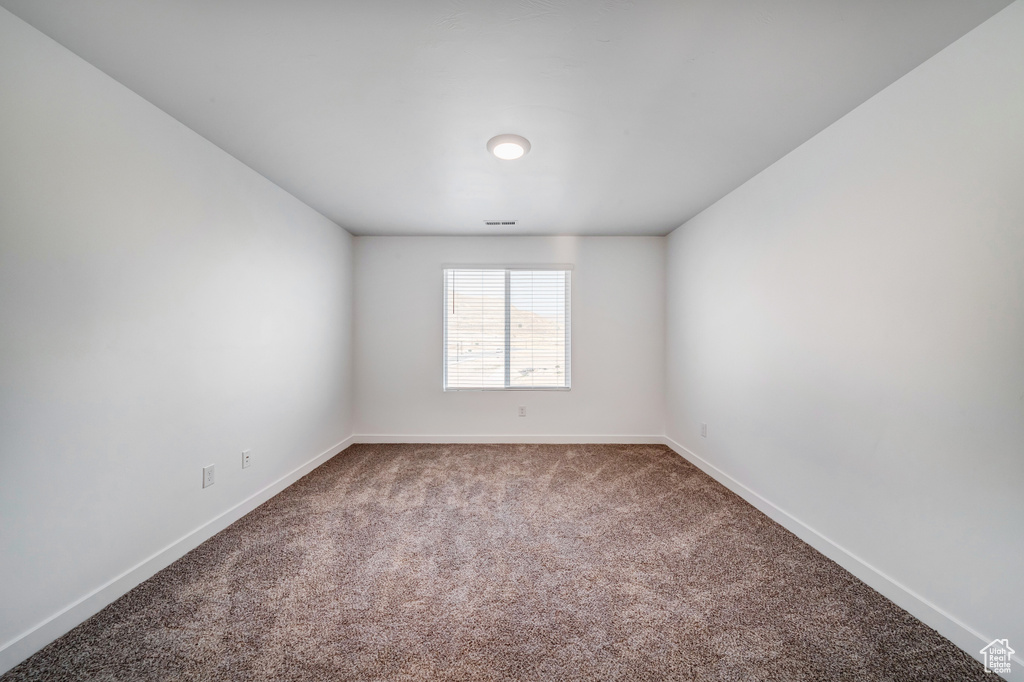 Spare room with baseboards and carpet