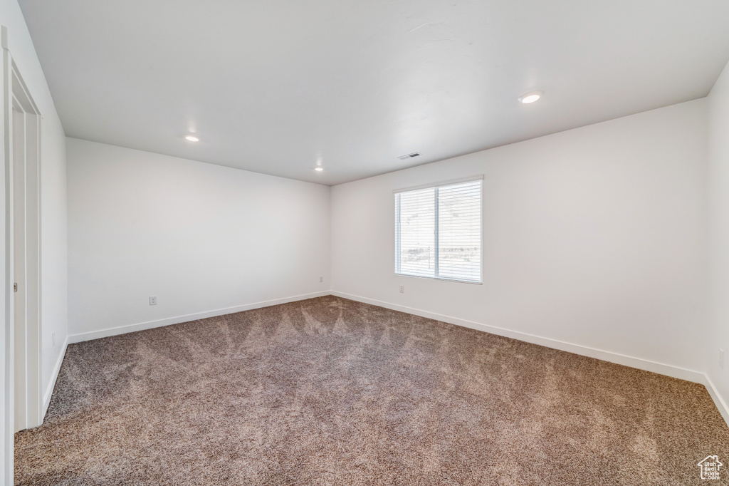 Carpeted spare room with baseboards, recessed lighting, and visible vents