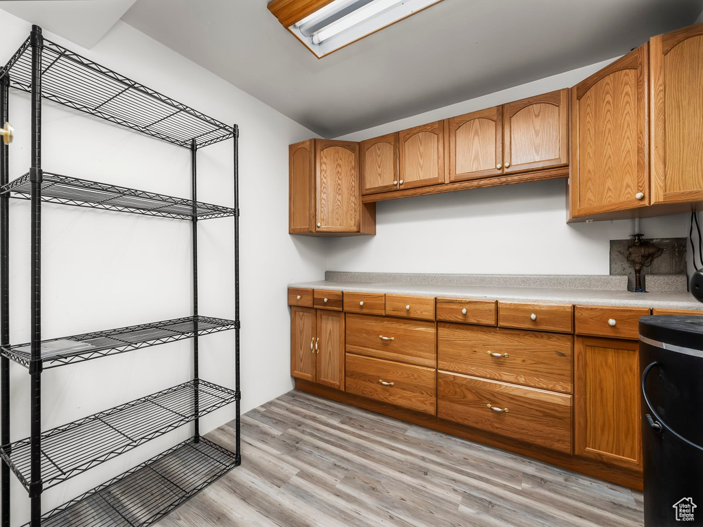 Kitchen featuring light countertops, light wood-style floors, and brown cabinetry