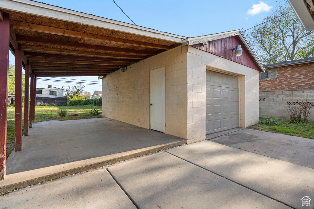 Garage featuring a detached garage and driveway