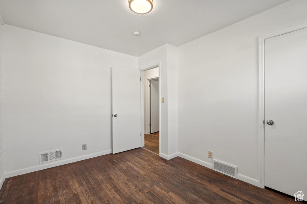 Spare room featuring baseboards, hardwood / wood-style floors, and visible vents