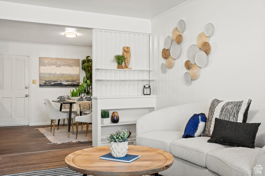 Living area with crown molding and wood finished floors
