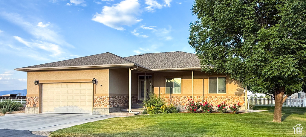 Single story home featuring stone siding, driveway, an attached garage, and stucco siding