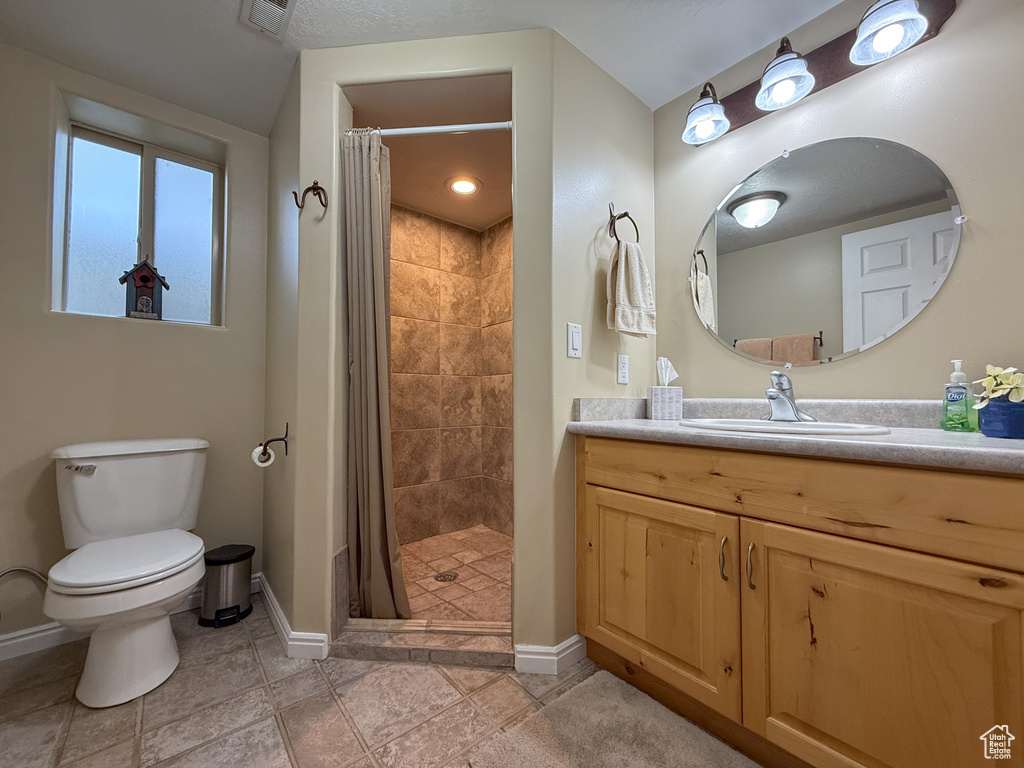 Full bath with vanity, toilet, baseboards, tile patterned floors, and a shower stall