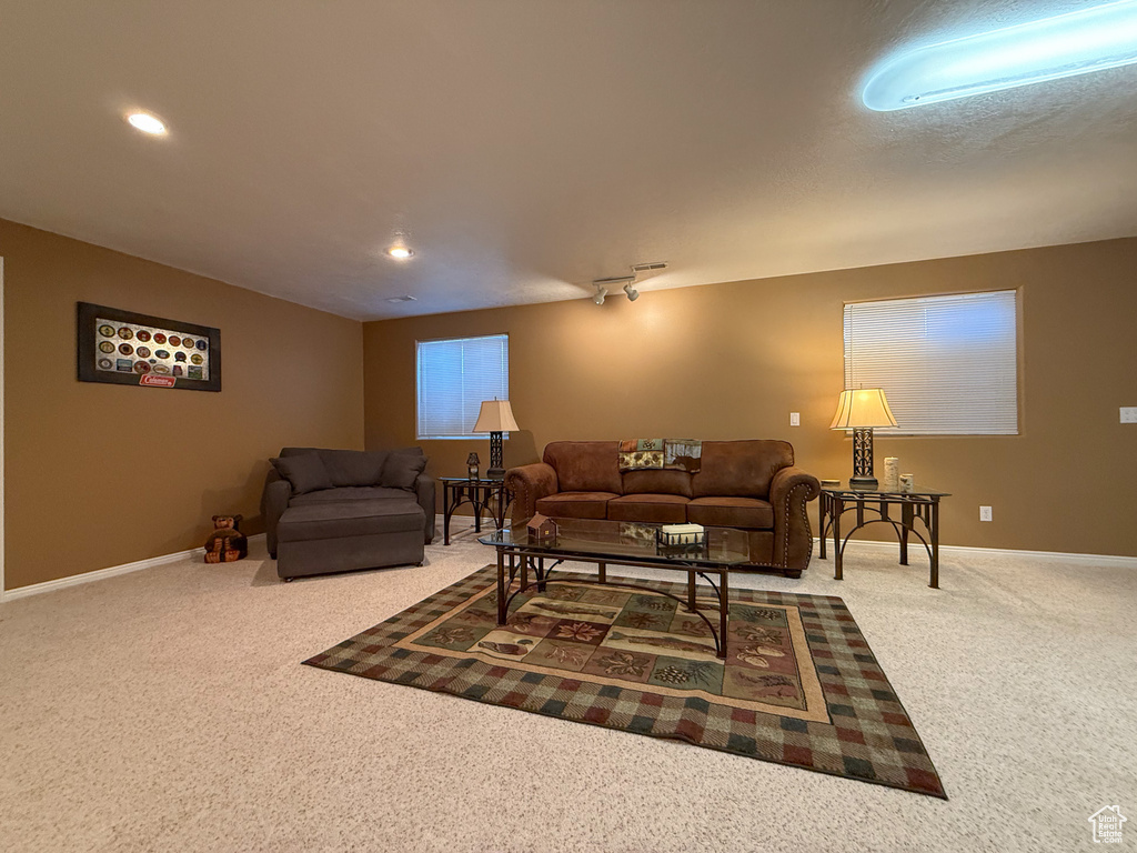 Carpeted living area with baseboards and recessed lighting
