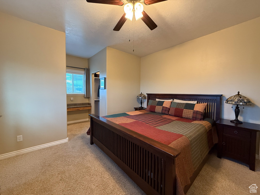 Bedroom with a ceiling fan, baseboards, and light colored carpet