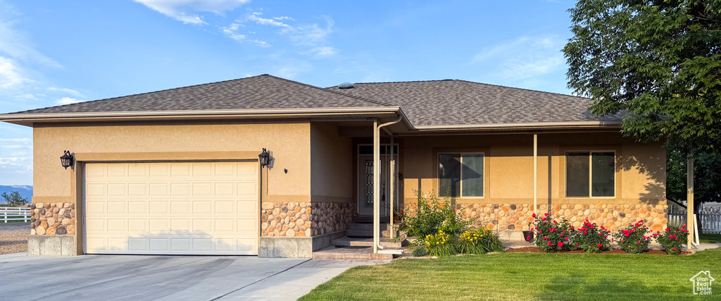 Ranch-style home with stone siding, stucco siding, driveway, a garage, and roof with shingles
