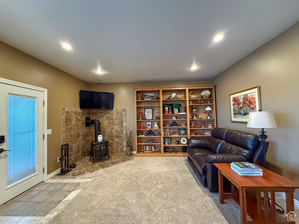 Carpeted living area with recessed lighting and a wood stove