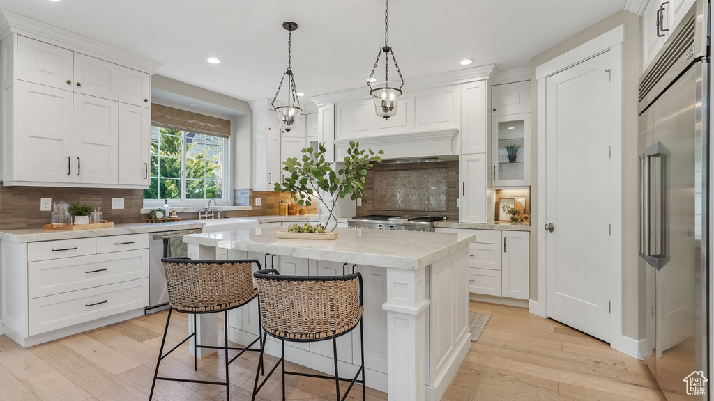 Kitchen featuring light wood-style flooring, appliances with stainless steel finishes, and white cabinetry