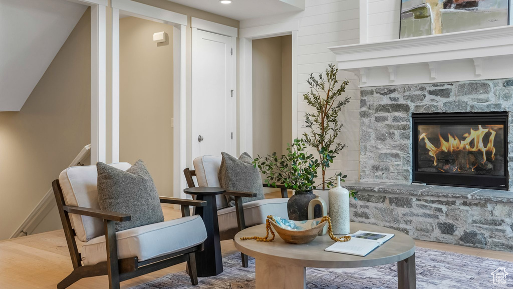 Living area featuring a stone fireplace and wood finished floors