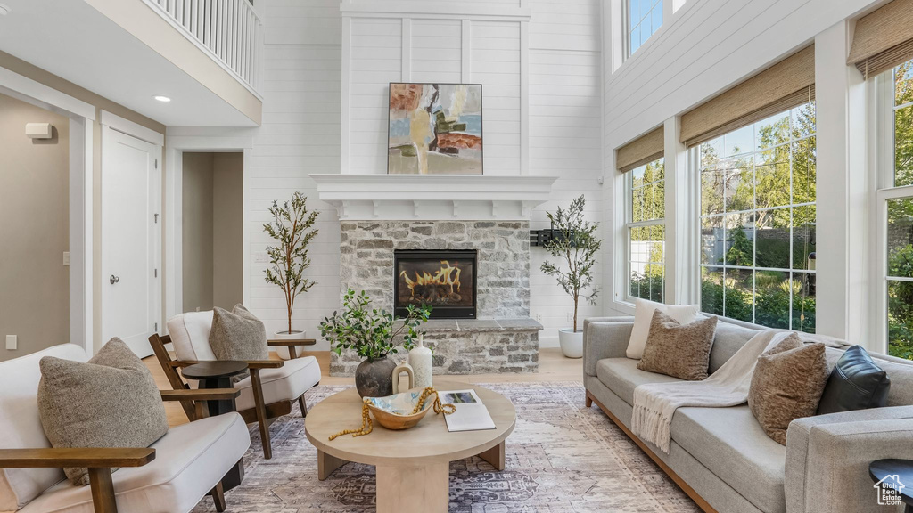 Interior space featuring wood walls, a towering ceiling, wood finished floors, and a fireplace
