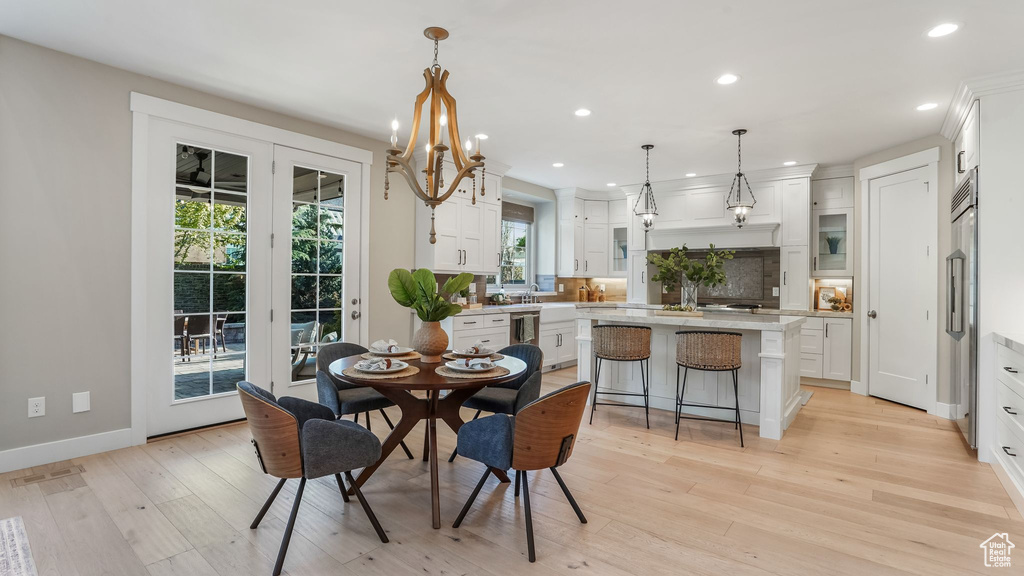 Dining area with recessed lighting, light wood-style flooring, baseboards, and a notable chandelier