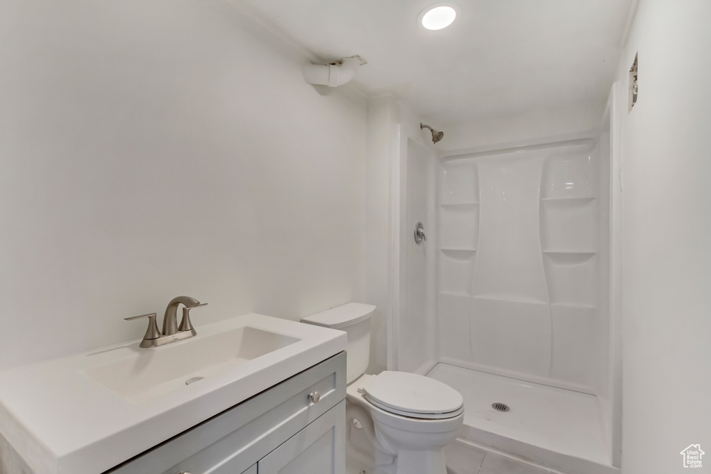 Bathroom featuring vanity, tile patterned floors, a stall shower, and toilet