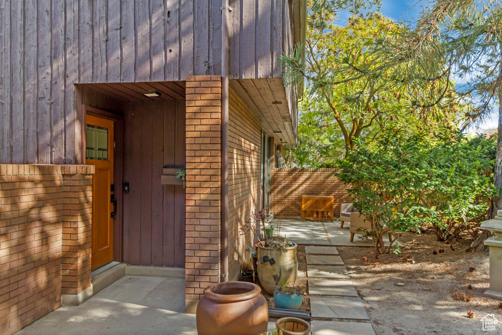 Exterior space featuring brick siding, fence, and a patio
