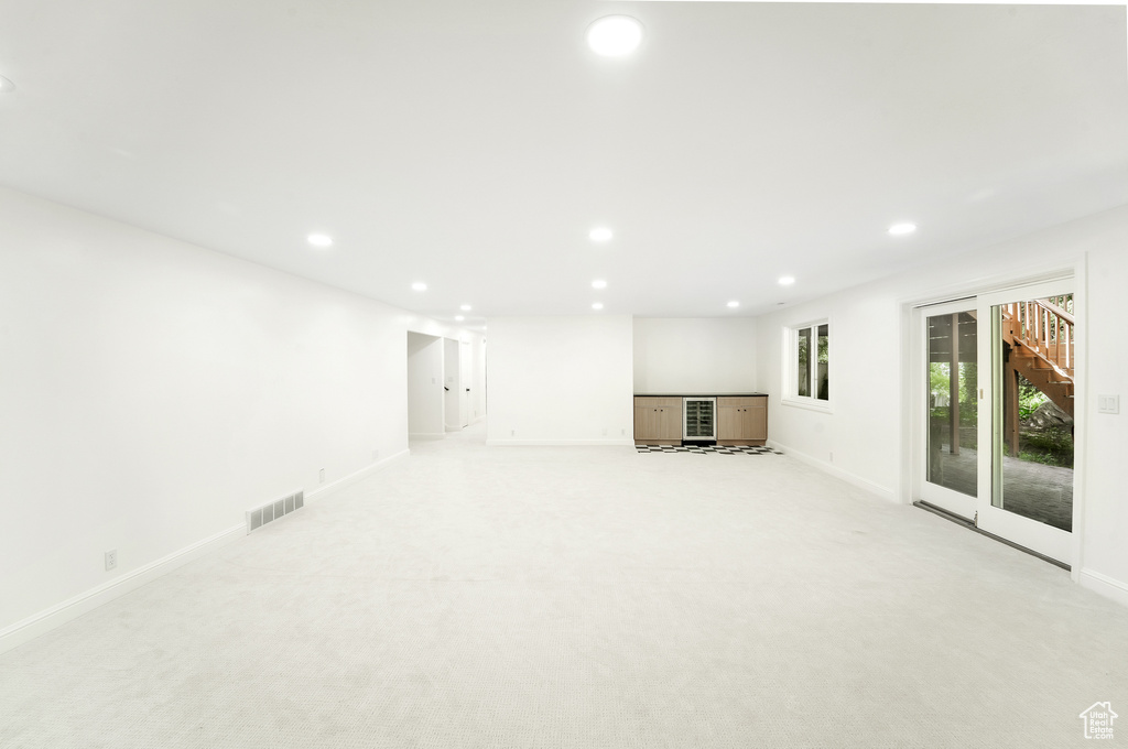 Interior space with visible vents, recessed lighting, baseboards, and light carpet