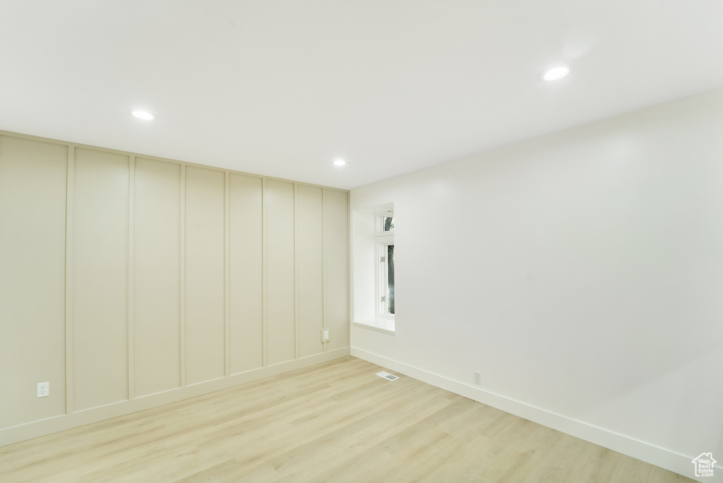 Empty room featuring recessed lighting, light wood-style floors, baseboards, and visible vents