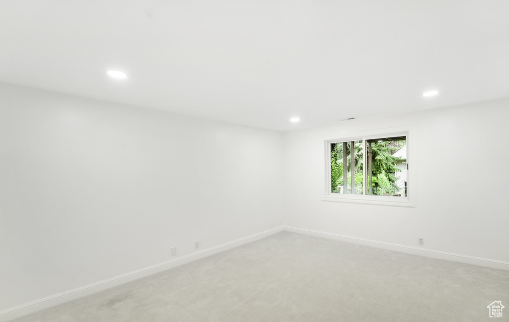 Empty room with recessed lighting, baseboards, and light carpet