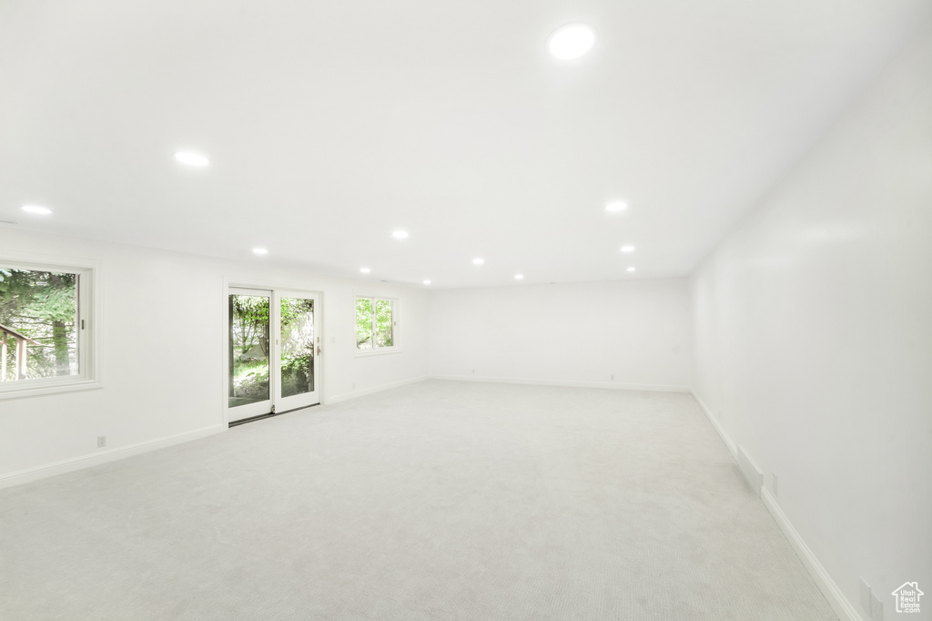 Spare room with baseboards, light carpet, and recessed lighting