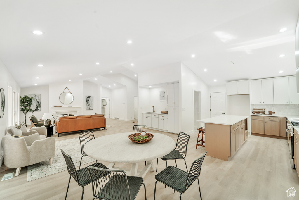 Dining area with light wood-type flooring, recessed lighting, and vaulted ceiling