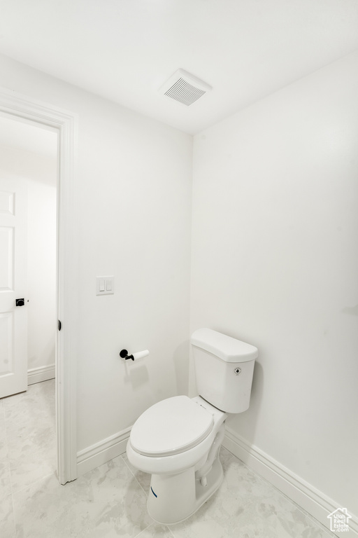 Bathroom with baseboards, toilet, and visible vents