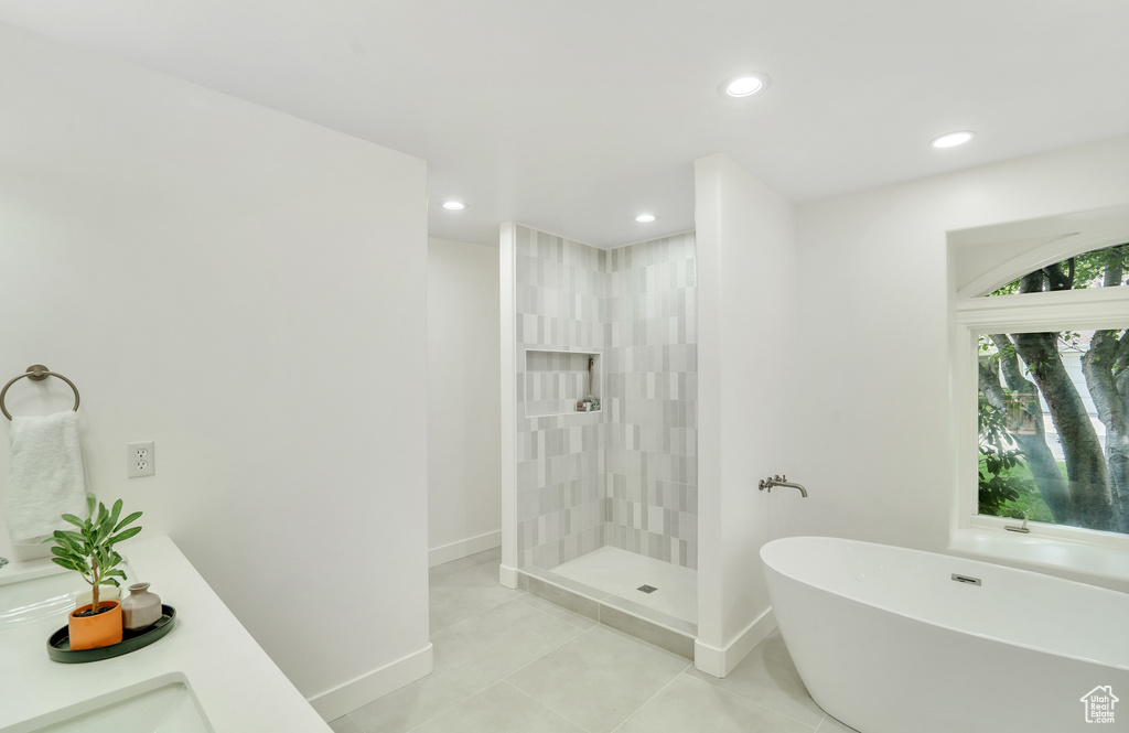 Full bathroom with a freestanding bath, baseboards, tile patterned floors, and recessed lighting