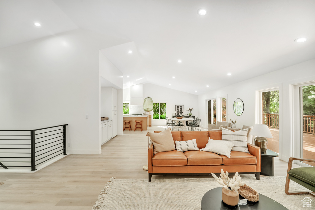 Living room with light wood-type flooring, vaulted ceiling, and recessed lighting