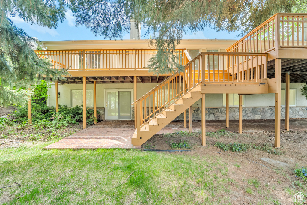 Back of property featuring stairway, a patio, a wooden deck, and stucco siding